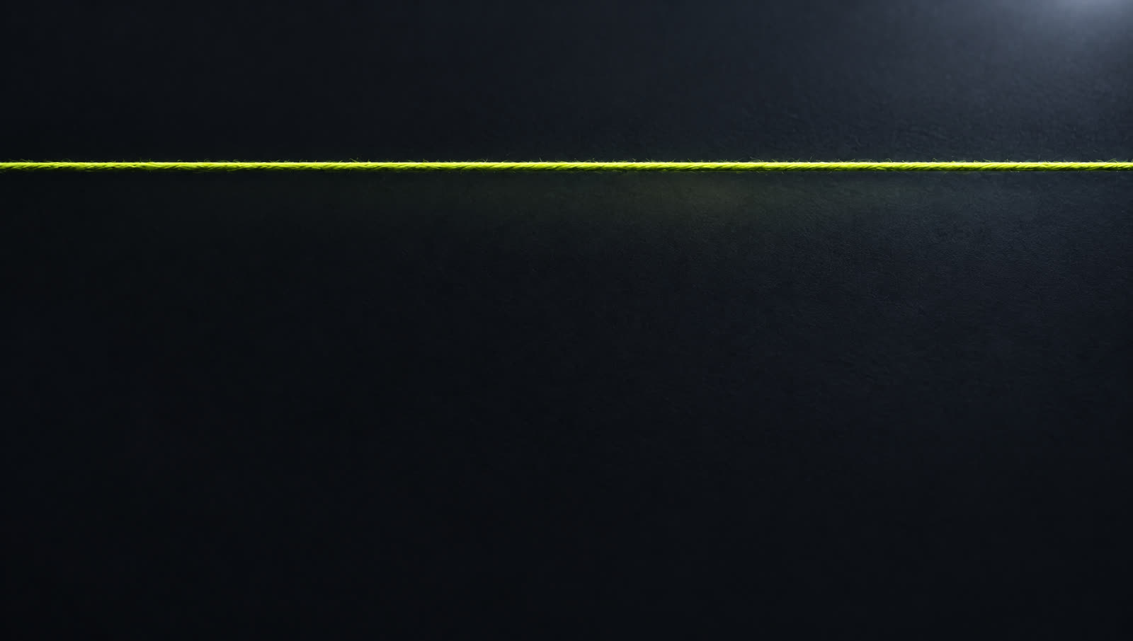 One straight lime thread alone on a dark field
